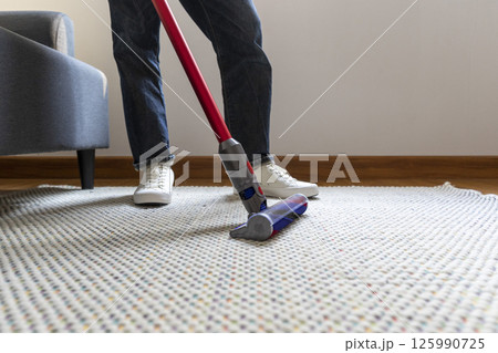 Man doing vacuum cleaning in room Man doing vacuum cleaning in room 125990725