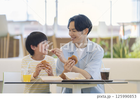 フードコードで食事をする親子　9歳の男の子と30代の父親 125990853