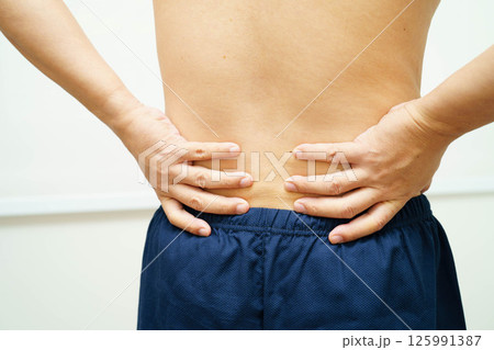 Asian man pain back muscle, spine and bone from accident. 125991387