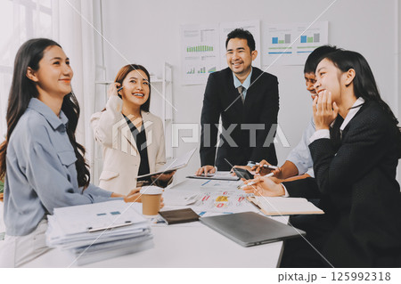 Team of financial advisory services. Asian advisor showing plan of investment to clients in the consultancy office. 125992318