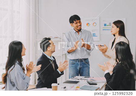 Team of financial advisory services. Asian advisor showing plan of investment to clients in the consultancy office. 125992320