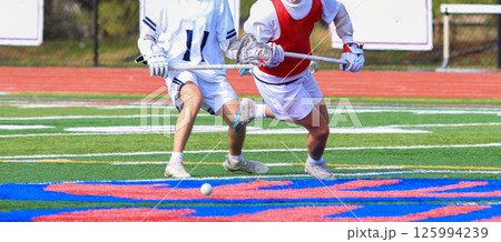 Two Youth Lacrosse Players Competing on a Field During a Game Two Youth Lacrosse Players Competing on a Field During a Game 125994239