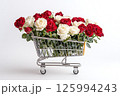 Shopping cart with red and white roses on white background and an empty space for text. Valentine's Day banner, template for advertisements of online shopping, flower delivery, weddings, floral gifts 125994243