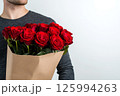 A man holding a bouquet of fresh red roses wrapped in kraft paper on white background, empty space for text. Template of Valentine's Day banner, card, flower delivery, shop advertisements 125994263