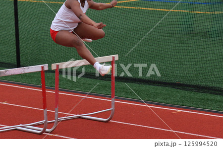 Athlete Jumps Over Hurdles During a Track Hurlde Rac3e Athlete Jumps Over Hurdles During a Track Hurlde Rac3e 125994520