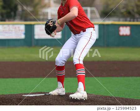 Baseball pitcher on the mound throwing a pitch during a game 125994523