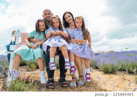 A young family enjoys a moment among purple lavender. A young family enjoys a moment among purple lavender. 125995405