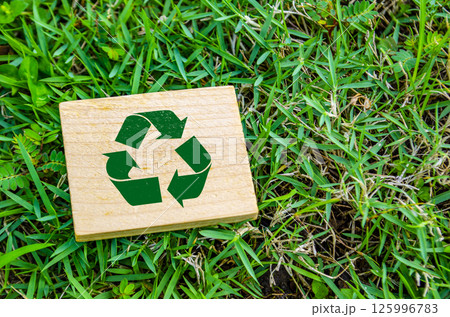 Top view of close up Recycle symbol on wooden block with customizable space for text. For a greener tomorrow concept 125996783