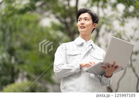 作業服を着てパソコンを持つ男性 作業服を着てパソコンを持つ男性 125997105