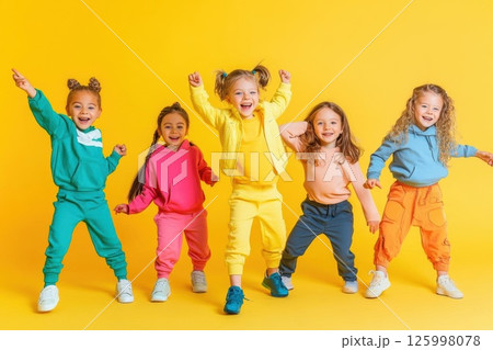 Kids Posing in Colorful Outfits on Yellow Background Kids Posing in Colorful Outfits on Yellow Background 125998078