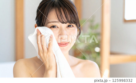 タオルで顔を拭く若い女性（AI生成画像） 125998332