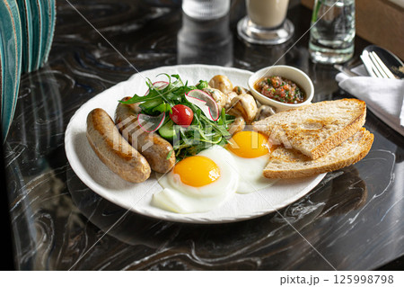 Breakfast with sausages and fried eggs 125998798