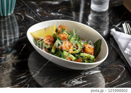 Portion of salad with fresh vegetables and shrimp 125998802