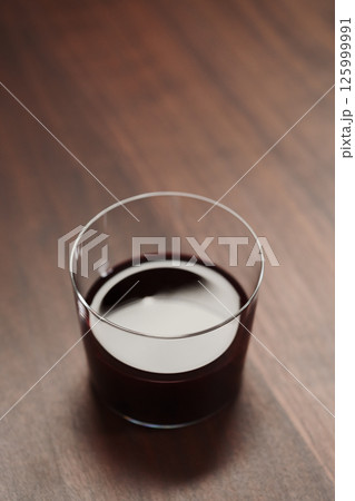 Red wine in tumbler glass on a walnut table with copy space Red wine in tumbler glass on a walnut table with copy space 125999991