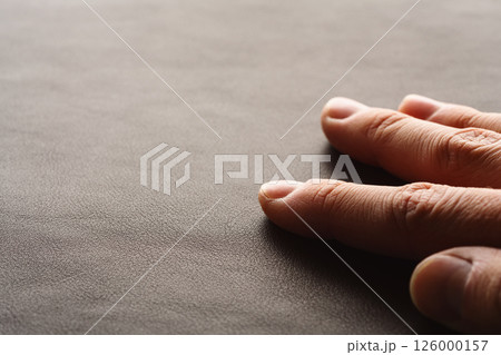 Closeup man hand check dark brown full grain leather Closeup man hand check dark brown full grain leather 126000157