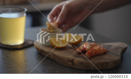 Man dip crab leg into pesto sauce with ginger beer on background 126000318