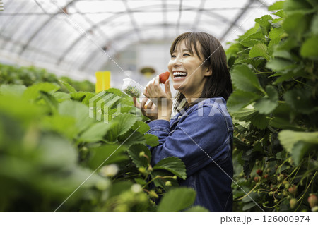 笑顔でいちごを持つ女性 126000974