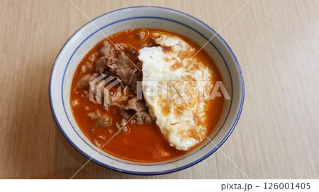 close up of tomato soup noodles with a pan fried egg and beef slice in a bowl with copy space close up of tomato soup noodles with a pan fried egg and beef slice in a bowl with copy space 126001405