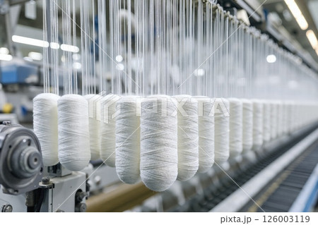 Modern textile industry scene capturing white yarn spools in high-tech environment Modern textile industry scene capturing white yarn spools in high-tech environment 126003119