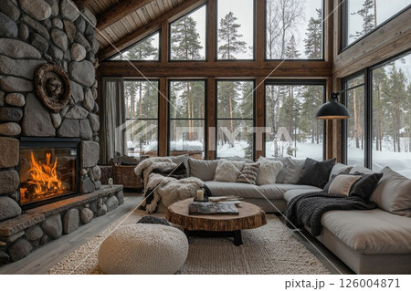 Cozy winter retreat in rustic cabin interior with stone fireplace and snowy forest view Cozy winter retreat in rustic cabin interior with stone fireplace and snowy forest view 126004871