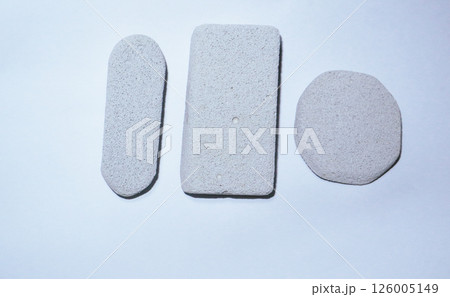 Grey pumice stone on white background, body care concept Grey pumice stone on white background, body care concept 126005149