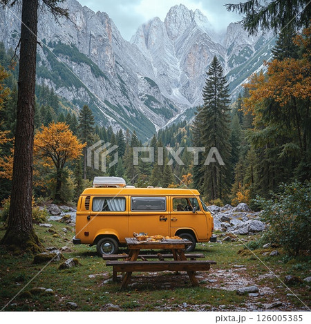 Vibrant yellow camper van in idyllic mountain forest setting for adventure travel inspiration 126005385