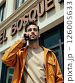 Urban elegance in autumn: fashionable young man on phone in orange jacket 126005633