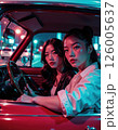 Urban night drive vibes: stylish women in retro car with neon city lights 126005637
