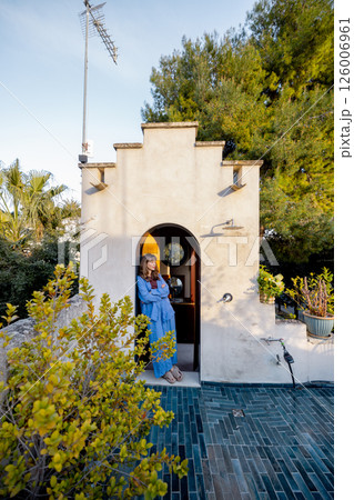 Woman relaxing at rustic rooftop shower entry in Mediterranean home 126006961