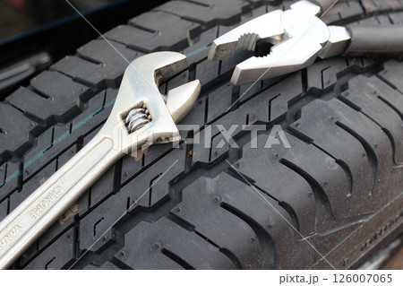 Pliers And Adjustable Wrench On A Spare Car Tire  126007065