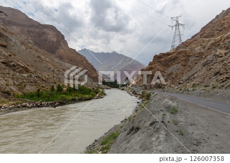 Asphalt road runs along Yaghnob river in mountainous valley Tajikistan Asphalt road runs along Yaghnob river in mountainous valley Tajikistan 126007358