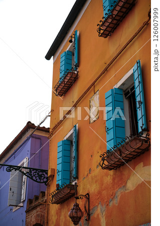 Colourful houses on the island of Burano, Italy, known for its brightly coloured facades and charming canals. Brightly coloured buildings line the narrow streets and waterways, horizontal photo Colourful houses on the island of Burano, Italy, known for its brightly coloured facades and charming canals. Brightly coloured buildings line the narrow streets and waterways, horizontal photo 126007999