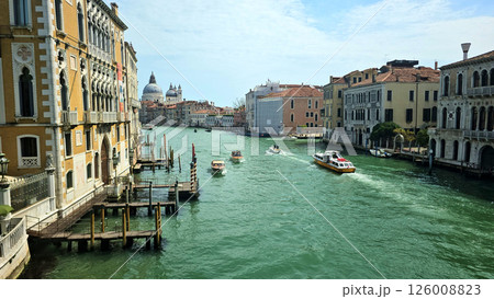 Picturesque view of a Venice canal taken from a bridge. Historic buildings with colorful facades Picturesque view of a Venice canal taken from a bridge. Historic buildings with colorful facades 126008823
