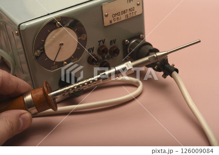 Retro soldering station. An old soldering iron with a silver tip. Retro soldering station. An old soldering iron with a silver tip. 126009084