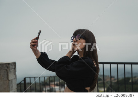 Woman Taking A Photo Selfie In The Village Square During The Day Woman Taking A Photo Selfie In The Village Square During The Day 126009387