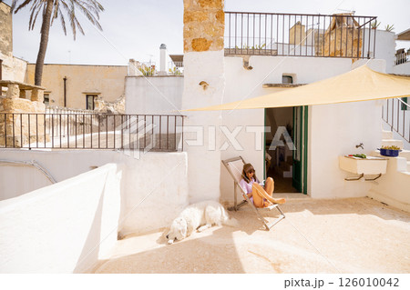 Mediterranean rooftop escape with dog and book 126010042