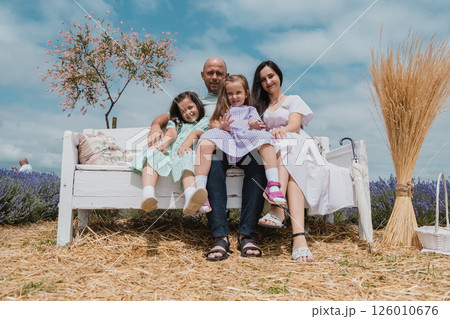 A happy family resting on a retro bench. A happy family resting on a retro bench. 126010676
