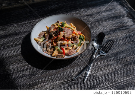 Pasta with beef, mushrooms and vegetables.  126010695