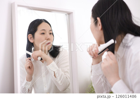 ヘアアイロンで髪を巻くミドル女性 ヘアアイロンで髪を巻くミドル女性 126011486