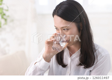リビングで水を飲むミドル女性 リビングで水を飲むミドル女性 126011497