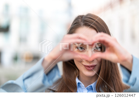 Portrait of smiling woman making heart shape with Portrait of smiling woman making heart shape with 126012447