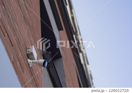 CCTV camera on the wall of a residential building for surveillance and protection in an urban area. CCTV camera on the wall of a residential building for surveillance and protection in an urban area. 126012720
