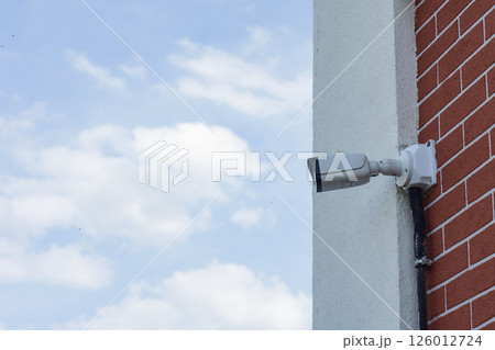 CCTV camera on the wall of a residential building for surveillance and protection in an urban area. CCTV camera on the wall of a residential building for surveillance and protection in an urban area. 126012724