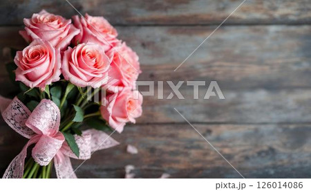 A wooden table decorated with pink roses and a ribbon, commemorating International Women's Day A wooden table decorated with pink roses and a ribbon, commemorating International Women's Day 126014086
