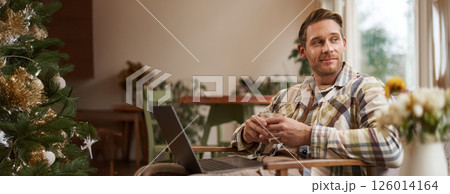 Handsome young professional, businessman sitting in cafe with glass of coffee and working on laptop, searching for inspiration outside of office workspace Handsome young professional, businessman sitting in cafe with glass of coffee and working on laptop, searching for inspiration outside of office workspace 126014164