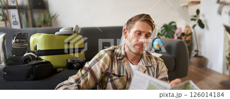Portrait of man, traveller looks confused at map, studying the route to go on vacation or business trip 126014184