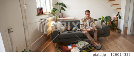 Portrait of man, tourist makes plans for his next vacation, writing a list of things to take with him, making a check-list 126014335