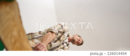 Image of funny man trying to close the suitcase filled with pile of clothes, packing luggage, putting things inside the bag Image of funny man trying to close the suitcase filled with pile of clothes, packing luggage, putting things inside the bag 126014404