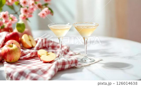 A table adorned with two glasses of apple cider and fresh apples, perfect for springtime cocktails 126014638