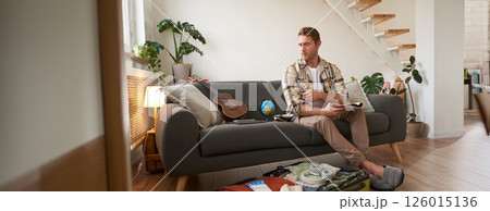 Portrait of traveller preparing for another journey, tourist packs suitcase with clothes for holiday, going on vacation Portrait of traveller preparing for another journey, tourist packs suitcase with clothes for holiday, going on vacation 126015136